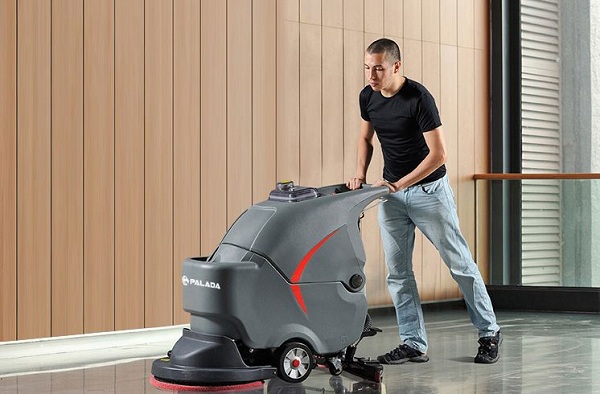 Người đàn ông sử dụng máy chà sàn nhà xưởng